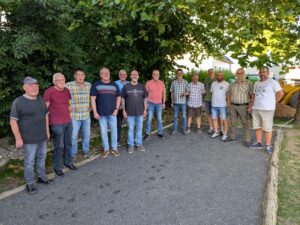 Teilnehmer der Boule-Meisterschaft stehen gemeinsam auf dem Bouleplatz.